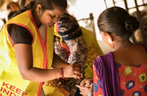 A healthcare worker vaccinating a child in a rural Indian village